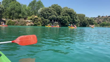 Menschen,-Die-An-Einem-Sonnigen-Tag-In-Spanien-Im-Türkisfarbenen-Wasser-Eines-Sees-Kajak-Fahren