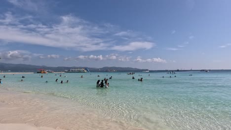 People-Swimming-and-Enjoying-the-Refreshing-Crystal-Clear-Water-at-White-Beach-in-Boracay-Island,-Philippines