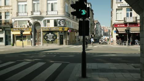 Silhouette-of-Orthodox-Jew-on-bike-crossing-the-city-street-in-the-famous-Antwerp-diamond-quarter,-Belgium---Wide-angle