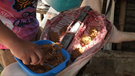 22-De-Abril-De-2023-Ciudad-De-Danao,-Cebú,-Filipinas---Un-Hombre-Está-Rellenando-Un-Lechon-Baboy-O-Cochinillo-Con-Una-Variedad-De-Ingredientes-Preparándolo-Para-Asarlo-Al-Fuego