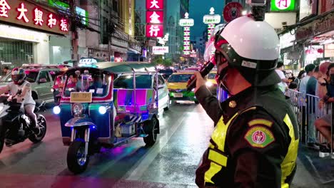 Oficial-De-Policía-De-Tránsito-Tailandés-En-El-Barrio-Chino-De-Bangkok-Por-La-Noche-Saludando-Al-Tráfico