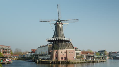 Patrimonio-Holandés:-Histórico-Molino-De-Viento-Junto-Al-Agua-En-Haarlem,-Países-Bajos,-En-Un-Día-Soleado