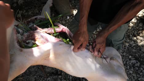 22-De-Abril-De-2023-Ciudad-De-Danao,-Cebú,-Filipinas---Un-Hombre-Está-Cosiendo-Un-Lechon-Baboy-O-Cochinillo-Preparándolo-Para-Asarlo-Al-Fuego