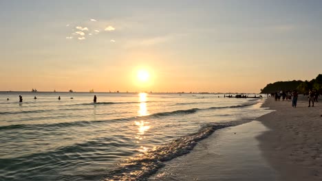 Menschen,-Die-Am-Strand-Spazieren-Gehen-Und-Den-Wunderschönen-Sonnenuntergang-Genießen,-Der-Den-Himmel-Auf-Der-Insel-Boracay,-Philippinen,-Gelb-Und-Orange-Färbt