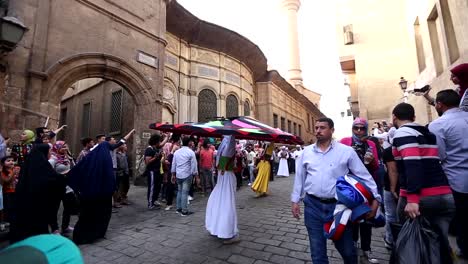 Egyptian-man-performs-traditional-belly-dance-for-tourists-in-Al-Moez-Ldin-Allah-Al-Fatmi-street,-Cairo,-Egypt