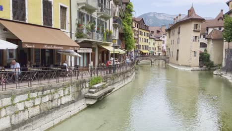 Shallow-river-flowing-through-canal-in-old-town-Annecy,-mecca-for-tourists