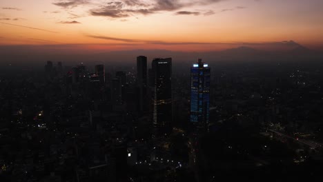 Drone-shot-rotating-away-from-the-Ritz-carlton-hotel-and-the-BBVA-tower,-dusk-in-Mexico-city