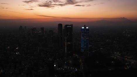 Disparo-De-Un-Dron-Girando-Alejándose-Del-Hotel-Ritz-Carlton-Y-De-La-Torre-BBVA,-Al-Anochecer-En-La-Ciudad-De-México