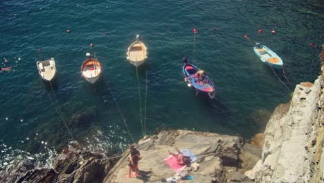 Italienische-Fischerboote-Legten-An-Einem-Heißen,-Sonnigen-Sommertag-In-Riomaggiore,-Italien,-Im-Wunderschönen-Cinque-Terre-Am-Wasser-An