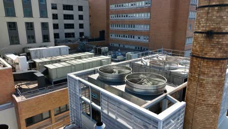 Aerial-establishing-shot-of-Air-Conditioner-on-rooftop-office-in-downtown-USA-city-during-hot-summer-day---Climate-change-on-earth