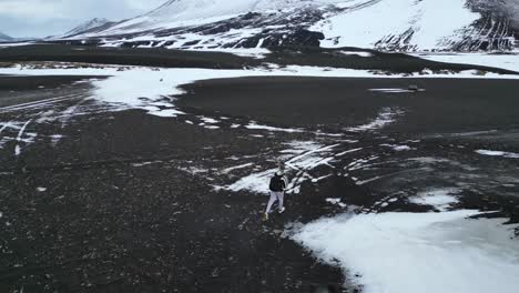 Drone-View-Following-Man-Walking-in-Icelandic-Landscape-in-Wintertime