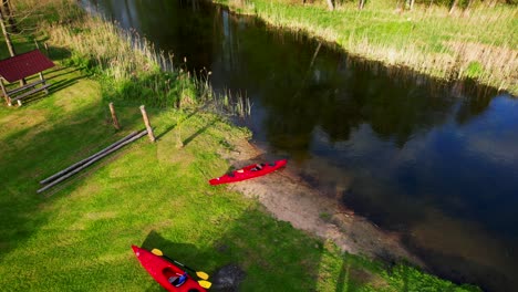 A-red-kayak-standing-on-the-shore-of-a-wild-river,-Hańcza