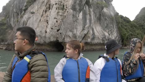 "A-GoPro-POV-tilt-up-footage-capturing-tourists-sitting-in-a-small-boat-while-exploring-Halong-Bay-in-Vietnam