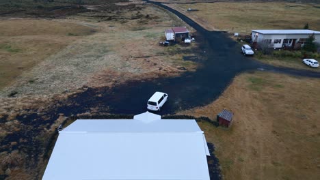 Man-Flying-with-Drone-from-Porch-at-Home-in-Iceland,-Aerial-View
