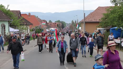 Eine-Vielfältige-Menschenmenge-Geht-Auf-Der-Csiksomlyo-Pilgerfahrt-Die-Straße-Hinauf-In-Richtung-Kamera