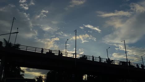 People,-pedestrian,-vehicles-passing-over-bridge-at-sunset-in-Dhaka,-Bangladesh