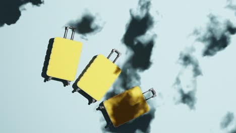 Three-yellow-suitcases-roll-in,-clouds-overlay,-concept-travel-by-plane,-static