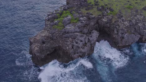 Rocky-coastline-with-small-waves-at-Sumba-island-Indonesia-during-sunrise,-aerial