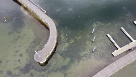 Kreisförmige-Luftaufnahme-Des-Bodensees-Mit-Seinen-Kleinen-Piers,-Umgeben-Von-Ruhigem-Wasser,-Mitten-In-Den-Alpen,-Bregenz-In-Österreich