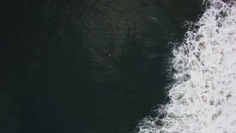 Weiße-Wellen-Auf-Dem-Pazifischen-Ozean-Mit-Einer-Person,-Die-Auf-Der-Oberfläche-In-Tofino,-BC,-Kanada-Paddelt