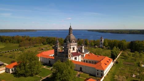 Aerial-shot-of-old-Pazaislis-Monastery-and-Church-on-sunny-day-with-blue-clear-sky,-in-Kaunas,-Lithuania,-parallax-shot