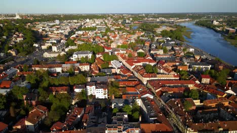 Aerial-shot-of-historic-houses-and-narrow-streets-in-Kaunas-old-town-by-a-Nemunas-river-in-Lithuania-on-a-sunny-evening