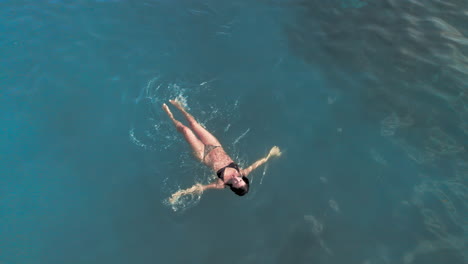 Aerial-full-body-shot-of-woman-swimming-in-the-sea