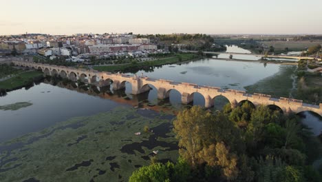 Die-Brücke-Puente-De-Palmas-Und-Der-Fluss-Guadiana-In-Badajoz,-Atemberaubende-Luftaufnahme-Der-Goldenen-Spanischen-Landschaft
