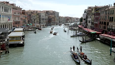 Peaceful-scene-of-Gondola-and-boats-navigating-Grand-Canal-in-Venice,-day