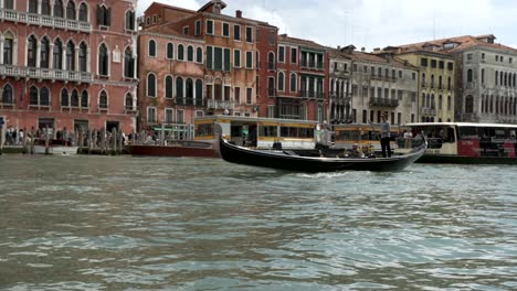 Low-angle-wide-establishing-shot-of-busy-boats-navigating-in-Venice-canal