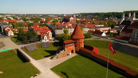Drone-shot-of-the-historic-old-red-brick-Kaunas-Castle-in-Kaunas-old-town,-Lithuania-on-a-sunny-day,-zooming-in