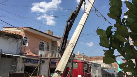 Trabajadores-De-La-Construcción-Levantando-Un-Pilón-De-Hormigón-Dañado-Junto-A-Las-Líneas-Eléctricas