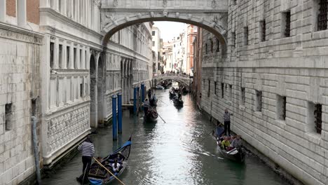 View-Of-Gondolas-with-Tourists-Going-Past-Under-Bridge-Of-Sighes-On-Rio-del-Palazzo-In-Venice