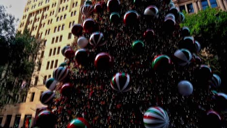 Editorial-illustrative-footage-depicting-a-stylized-Christmas-tree-assembled-out-of-ornamental-balls-and-glitter-displayed-at-one-of-the-streets-of-downtown-Sydney,-Australia,-in-December-2022