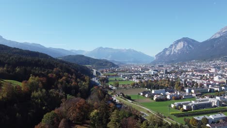 Innsbruck-En-Una-Vista-Aérea-Vertical-En-Un-Día-Soleado-Lleno-De-Tranquilidad-Otoñal-Con-Un-Bosque-Alpino-Verde-Y-Los-Alpes-En-El-Tirol-En-Austria