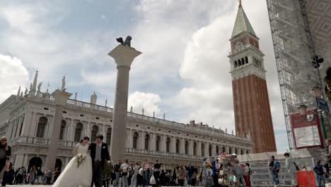 Hochzeitspaar-Macht-Fotos-Auf-Der-Piazza-San-Marco-Mit-Glockenturm-Im-Hintergrund-In-Venedig