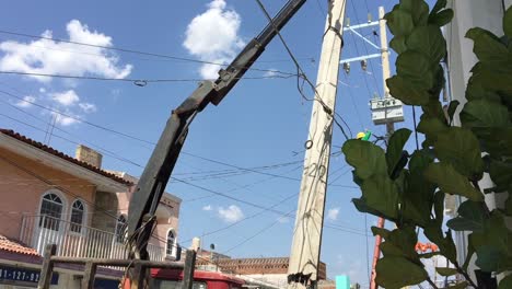 Construction-workers-in-hardhats-remove-concrete-utility-pole-on-city-street