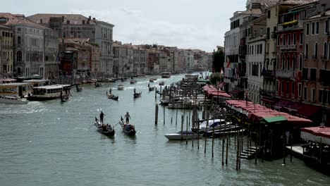 Eine-Wunderschöne-Aussicht-Von-Der-Rialtobrücke-Auf-Den-Belebten-Canal-Grande-Mit-Booten-Und-Gondeln,-Die-Entlang-Der-Berühmten-Wasserstraße-Fahren,-Venedig,-Italien