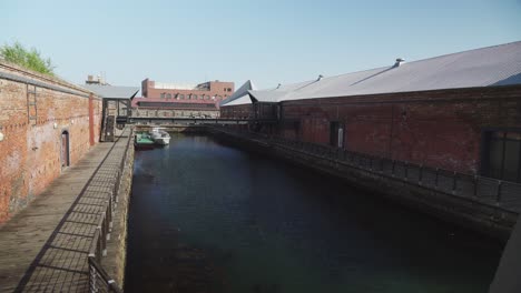 Truck-right-lone-dock-with-Kanemori-red-brick-warehouses,-lone-boat-parked-Hakodate-Japan
