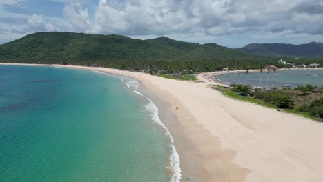 Panoramic-aerial-overview-of-nacpan-beach-and-couple-walking-on-shore