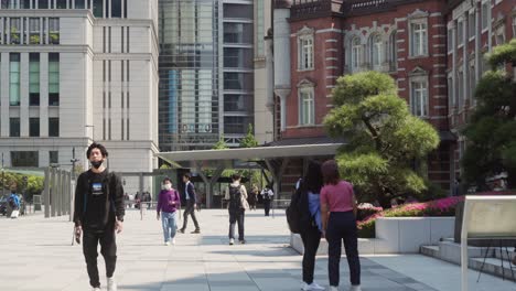 Establishing-view-of-Tokyo-station-and-Asian-people-walking-on-a-sunny-day,-Japan