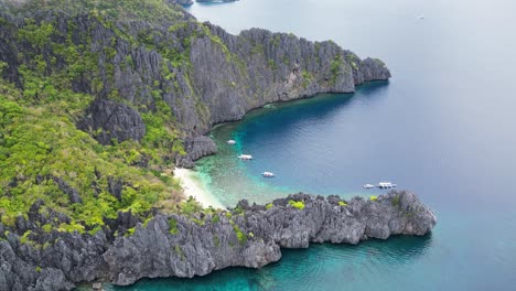 Scenic-beautiful-palawan-deep-water-bay-with-tall-rocky-cliffs-and-boats