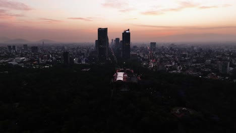 Drohnenaufnahme-Umkreist-Silhouetten-Wolkenkratzer-Der-Innenstadt-Von-Mexiko-Stadt,-Farbenfroher-Abend