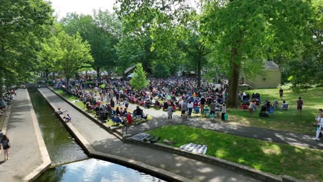Large-gathering-of-town-folk-at-a-park-enjoying-a-beautiful-summer-day