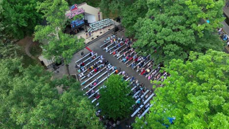 Panoramic-drone-view-of-Lititz-Springs-Park-fourth-of-July-celebration-outdoor-performances-at-a-park-amphitheater-on-a-beautiful-summer-afternoon