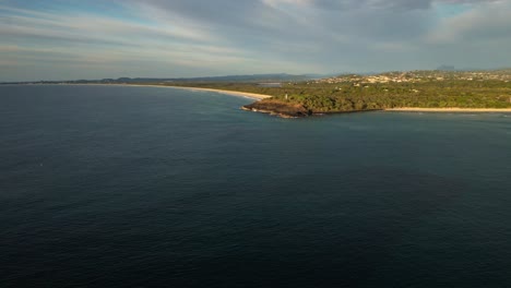 Approaching-aerial-of-Fingal-Head-and-Dreamtime-Beach,-Northern-New-South-Wales,-Australia