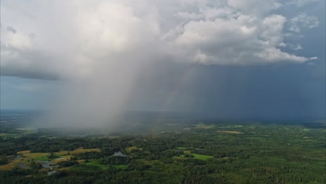 Rain-falls-from-a-distance-cloud,-with-a-rainbow-forming-in-contrast-to-the-storm-shadow