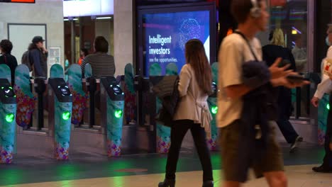 Commuters-rushing-their-way-towards-the-railway-platform,-passing-through-gates-and-paying-fares-by-tapping-their-go-card-or-credit-card-on-the-machines-at-Brisbane-City-Central-Station,-static-shot