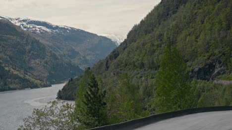 Hand-held-shot-of-a-road-turning-around-the-Fjord-in-Vestland,-Norway