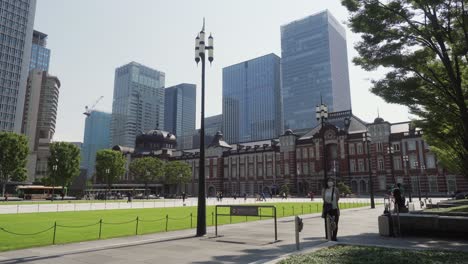 Establishing-view-of-Tokyo-Japan-Railway-Station-on-a-sunny-day,-contrast-of-ancient-and-modern-architecture